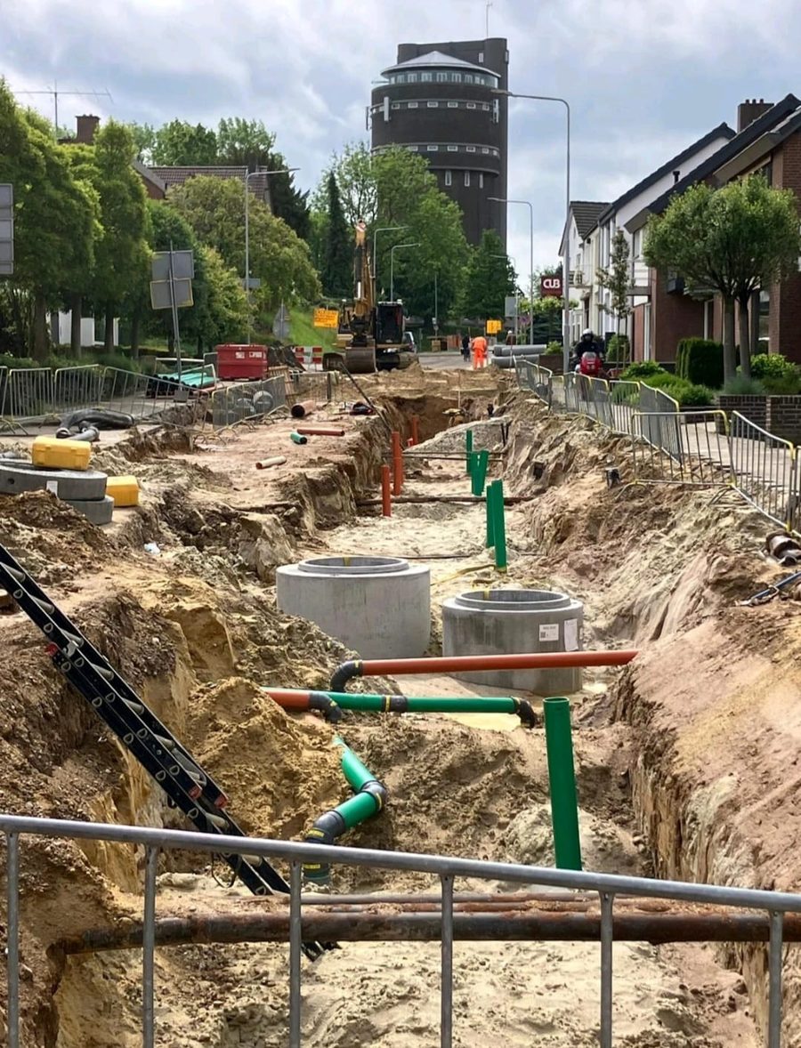Open sleuf met nieuwe riool- en kabelinfrastructuur in een woonstraat